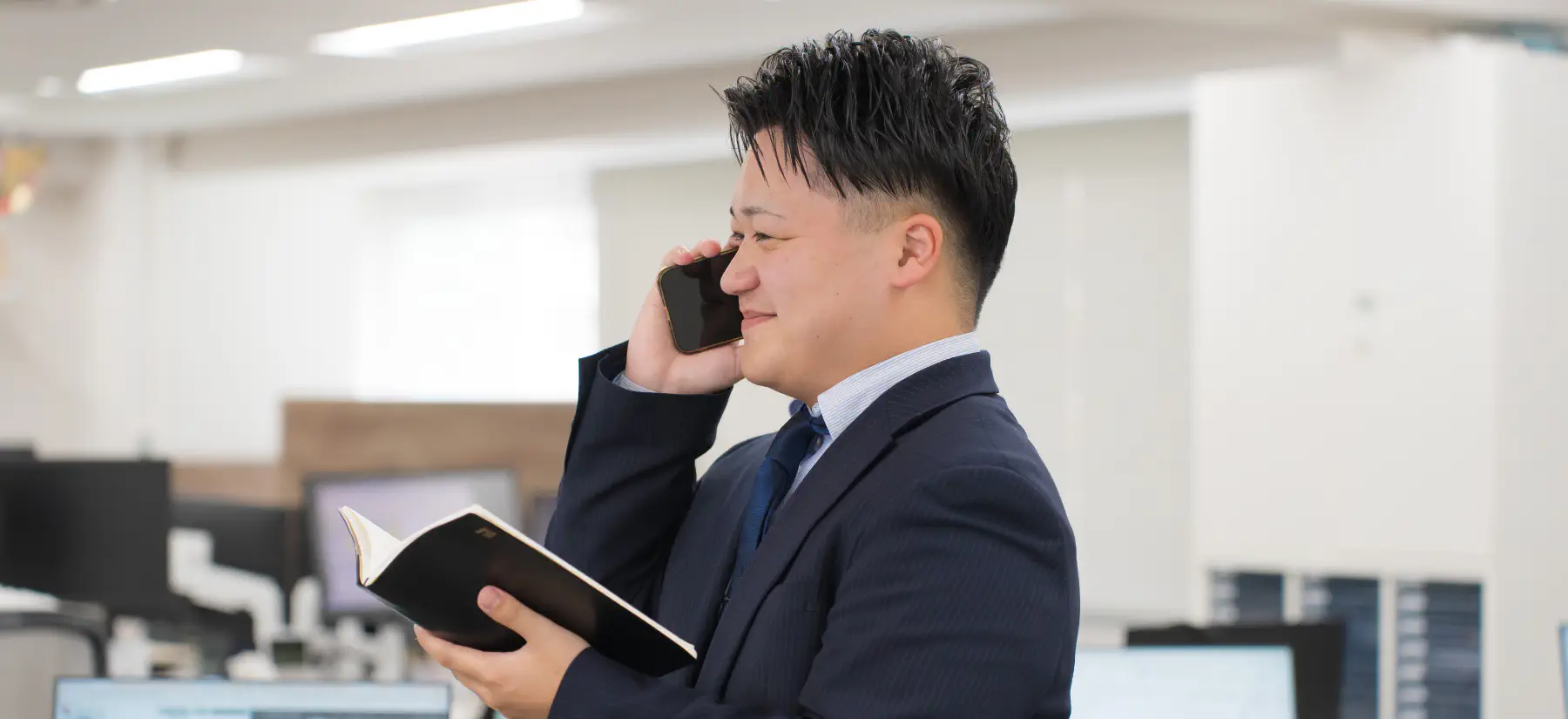 手帳を見ながら電話をする様子