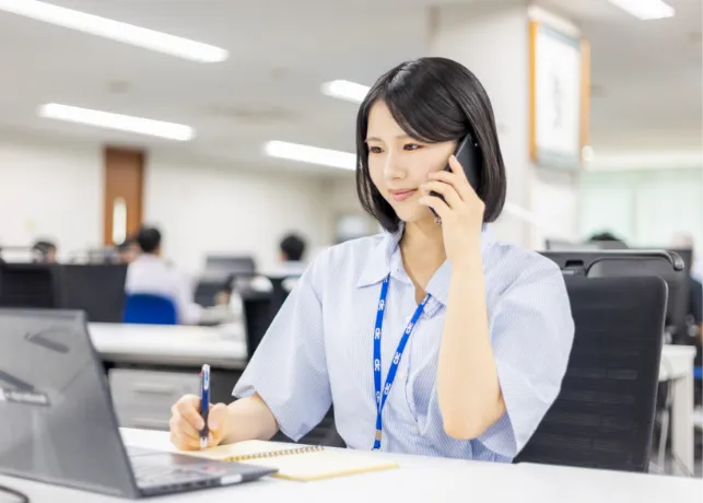メモを取りながら電話をする様子